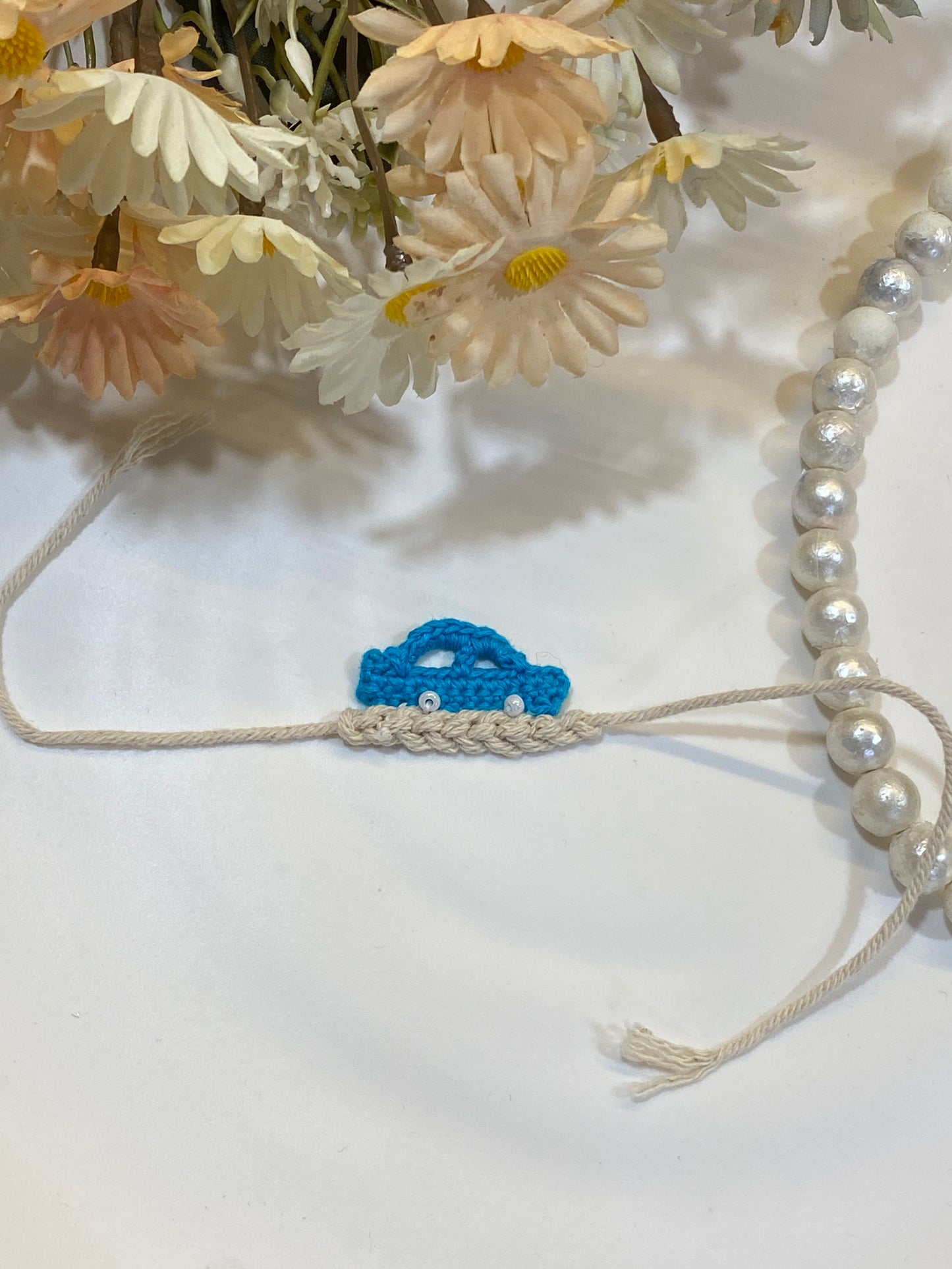 Handmade Blue Crochet Car Rakhi for Kids | Cute Beige Thread Rakhi with Pearl Detailing